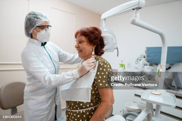 dentista prepara a mujer paciente para tratamiento dental - odontología cosmética fotografías e imágenes de stock