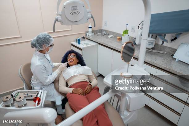 young woman at the dentist - general view stock pictures, royalty-free photos & images