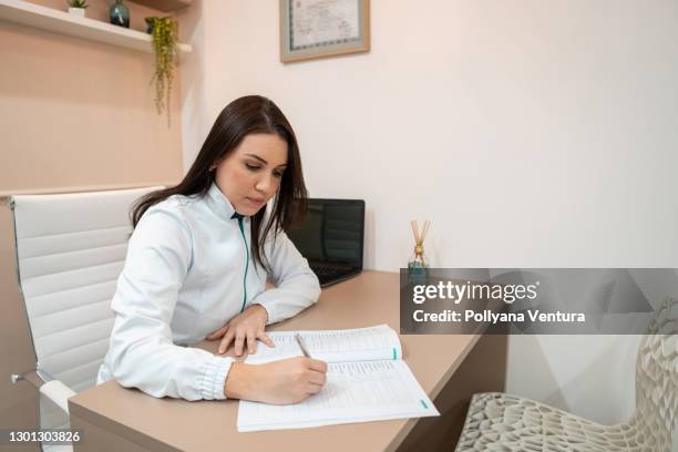 medical woman filling medical form - reference book stock pictures, royalty-free photos & images