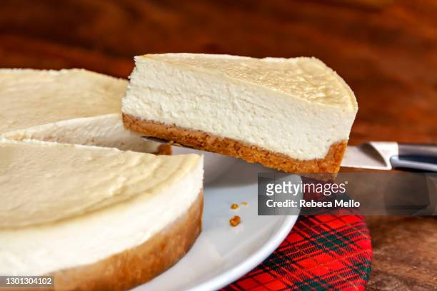 cheesecake slice on a knife - cheesecake imagens e fotografias de stock