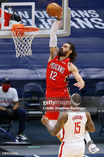 Steven Adams of the New Orleans Pelicans goes to the basket as DeMarcus Cousins of the Houston Rockets looks on during the first half at the Smoothie...