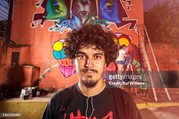 portrait of a street artist, in front of graffiti - painter artist stock-fotos und bilder