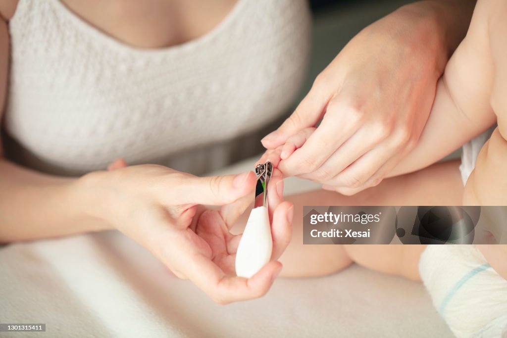 Mother cutting baby's nails