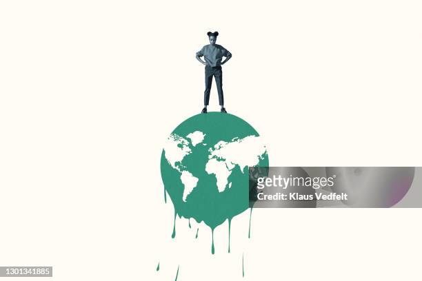 woman standing with hands on hip over melting planet earth - klimaatverandering stockfoto's en -beelden