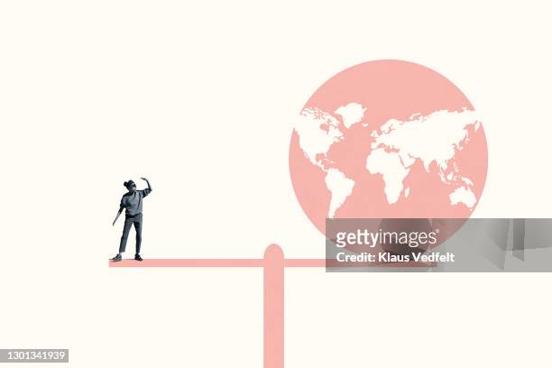 woman standing with coral planet earth on seesaw - in a perfect world imagens e fotografias de stock