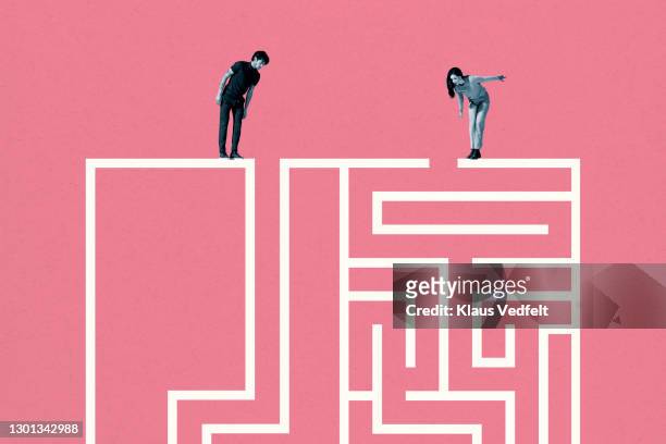 young man and woman standing on top of white maze - social inequality photos et images de collection