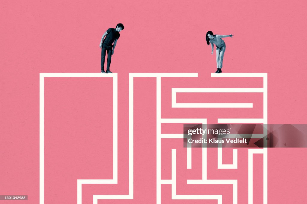 Young man and woman standing on top of white maze