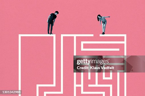 Young man and woman standing on top of white maze Young man and woman standing on top of white maze