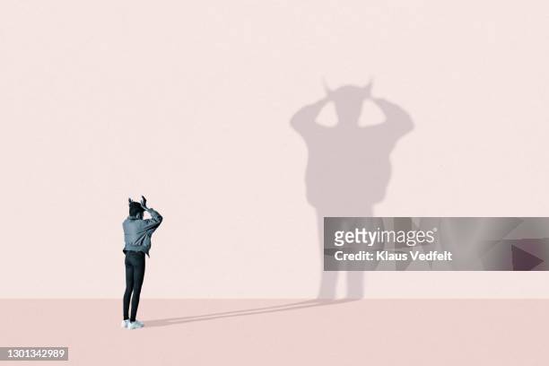 young woman making devil shadow - rabbia emozione negativa foto e immagini stock