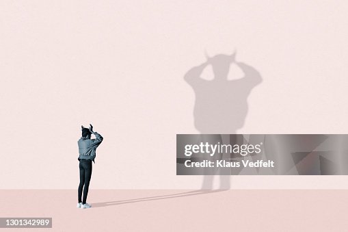 Young woman making devil shadow Young woman making devil shadow