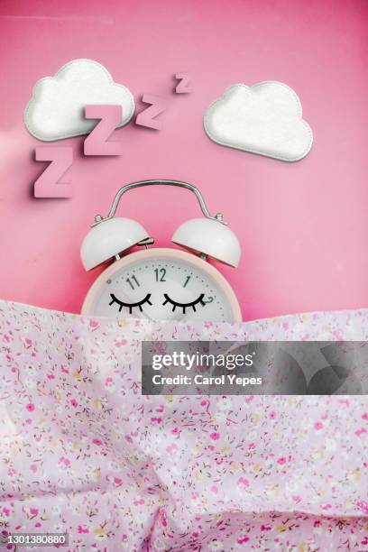 pink alarm clock sleeping in bed - daylight saving time stock pictures, royalty-free photos & images