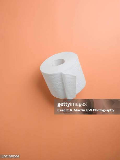 toilet paper roll on a colored background - toilet paper stock pictures, royalty-free photos & images