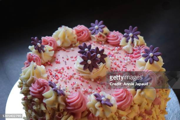 white and pink cakes decorated with colourful sprinkles and red hearts for valentine's day - decorating a cake fotografías e imágenes de stock