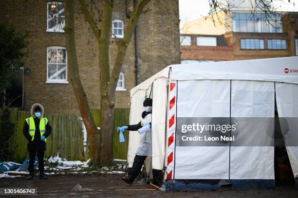 Member of the team emerges after cleaning one of the swabbing stations of a mobile testing centre on February 10, 2021 in London, England. Covid-19...