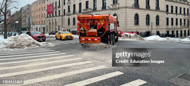 Manhattan, New York, A Sanitation Department truck spreading salt and san on a street in the Upper West Side area of Manhattan as snow is forcast.