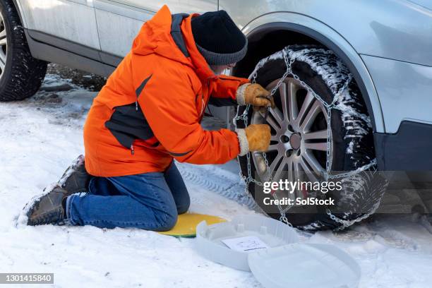 putting on snow chains - tyre chain stock pictures, royalty-free photos & images