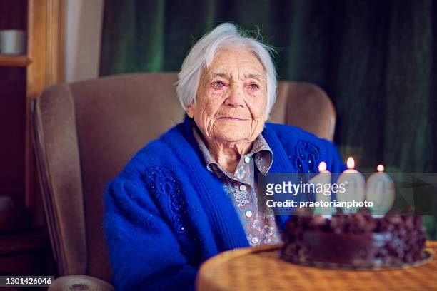 portrait of sad grandmother at her 100th birthday - 100 birthday imagens e fotografias de stock