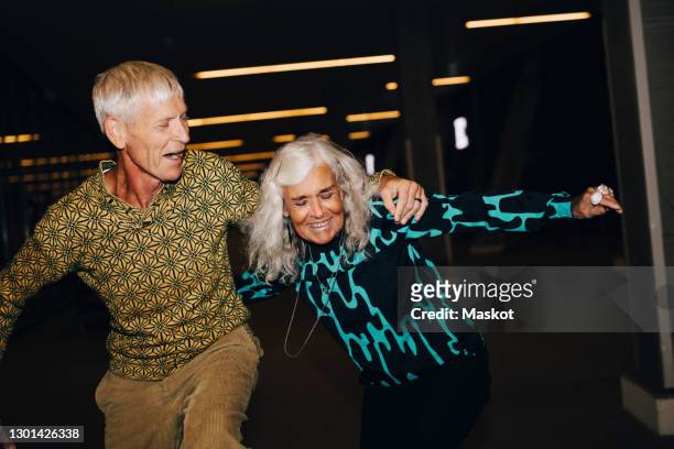 senior man and woman dancing in parking garage - senior women dancing stock pictures, royalty-free photos & images