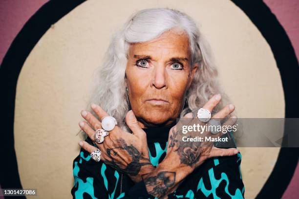 portrait of senior woman showing rings against wall - old woman tattoos stock pictures, royalty-free photos & images