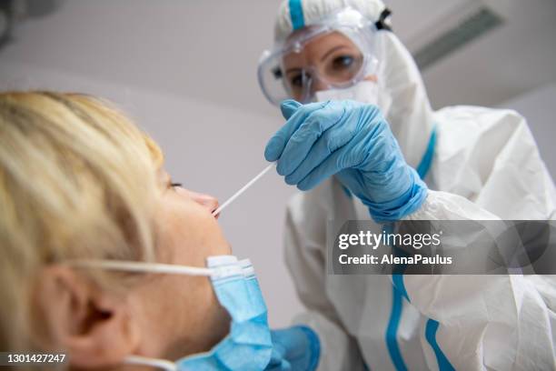 giovane specialista sanitario che prende il campione di tampone naso covid-19 dal suo paziente - coronavirus test foto e immagini stock