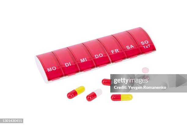 medicine organizer and pills on white background - dosing stock-fotos und bilder