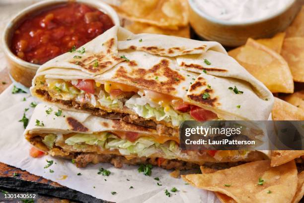 the cheesy beef crunch wrap supreme - quesadilla stock pictures, royalty-free photos & images