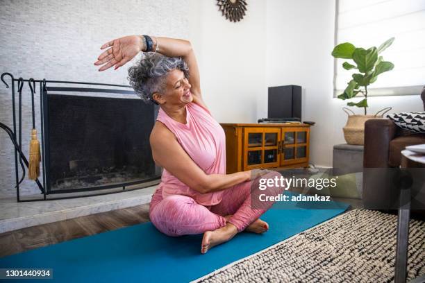 beautiful black woman doing yoga at home - yoga teacher stock pictures, royalty-free photos & images