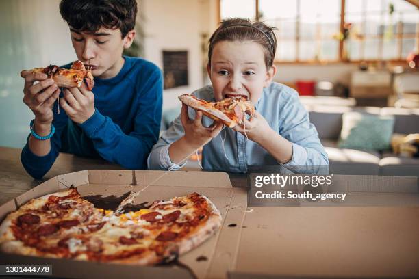 boys eating pizza together - pizza children stock pictures, royalty-free photos & images