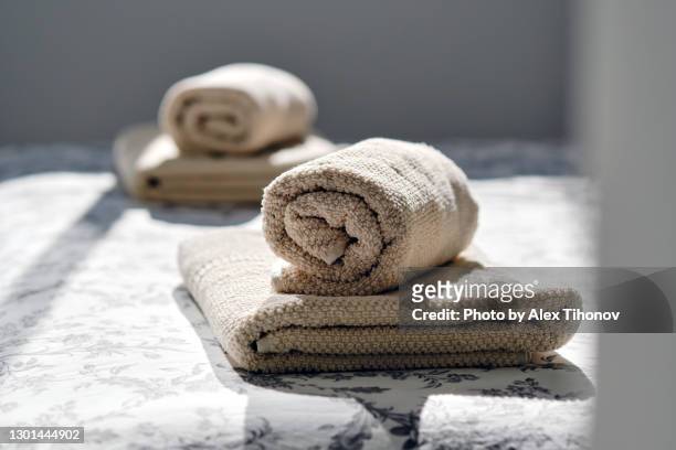 closeup two fresh clean folded rolled towels - towel stock-fotos und bilder