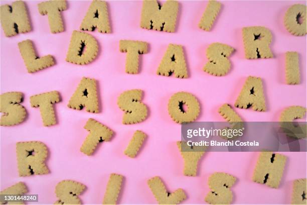 cookies in the form of letters on pink background - alphabet hand made stock-fotos und bilder