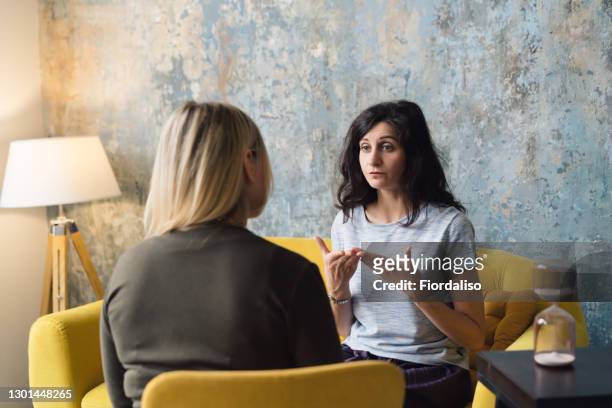 woman psychologist talking to patient - discussion foto e immagini stock