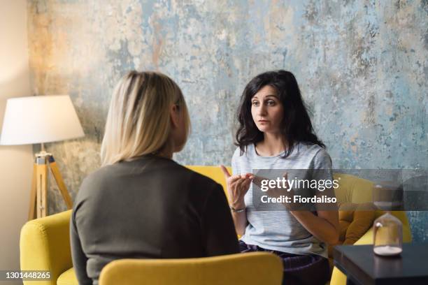 woman psychologist talking to patient - negatief praten stockfoto's en -beelden