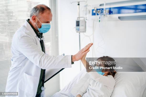 the sick child in the hospital bed , wearing a protective face mask - pediatric intensive care unit stock pictures, royalty-free photos & images