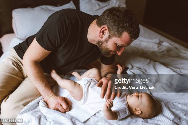 middle age caucasian father changing diaper for newborn baby daughter. male man parent taking care of child at home alone. authentic lifestyle candid moment. single dad family life concept. - adult baby boy diaper change foto e immagini stock
