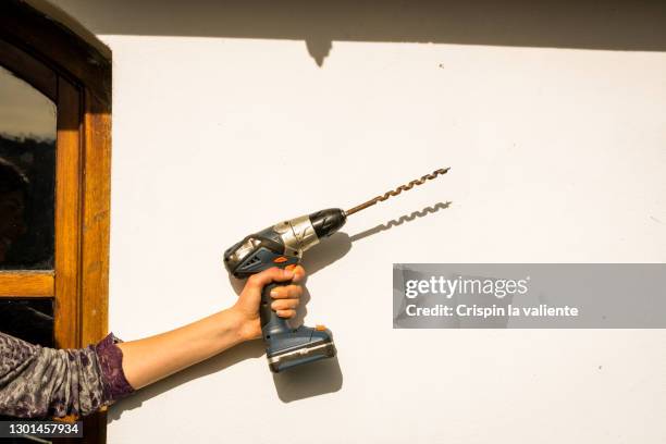 woman with a drill, house renovations - drill stockfoto's en -beelden