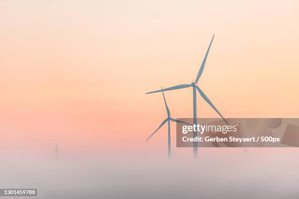 silhouette of wind turbine against sky during sunset,eeklo,belgium - wind photos et images de collection