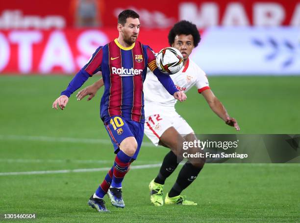 Lionel Messi of FC Barcelona battles for possession with Jules Koundé of Sevilla during the Copa del Rey Semi Final First Leg match between Sevilla...