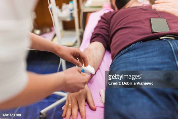 nurse helping patient with iv drip at the er - vitamin drip stock pictures, royalty-free photos & images