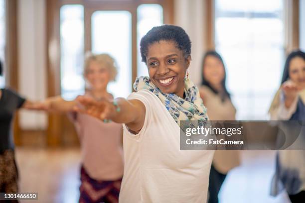 senior adult participating in yoga class - community centre stock pictures, royalty-free photos & images