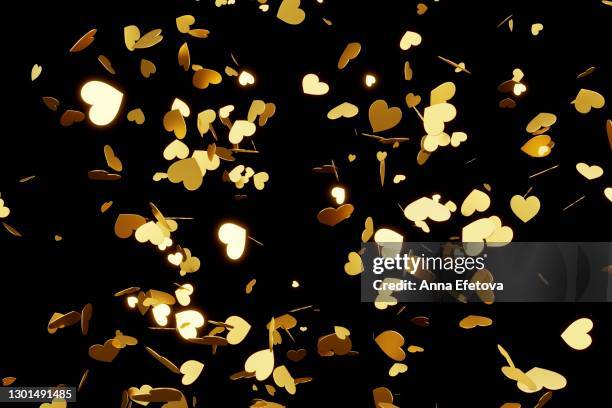 golden hearts confetti splashing over black background. valentine's day concept - gold heart stock-fotos und bilder