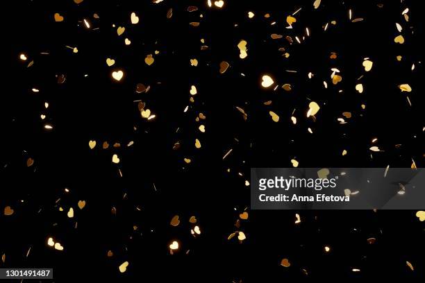 golden hearts confetti splashing over black background. valentine's day concept - falling in love stockfoto's en -beelden