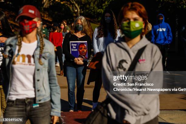 People listen during a press conference where students spoke out against the recent racist attacks on the Lowell community on Friday, Feb. 5, 2021 in...