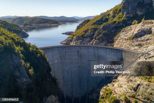 aerial view of enormous cement dam on a sunny day in tasmania, australia - top of the mountain australia stock pictures, royalty-free photos & images