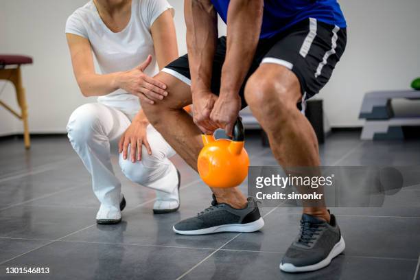 man exercising with yellow kettlebell - checking sports stock pictures, royalty-free photos & images