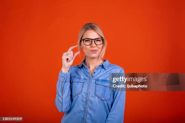 young beautiful brunette woman over isolated red background smiling and confident gesturing with hand doing small size sign - showing size with hands stock pictures, royalty-free photos & images