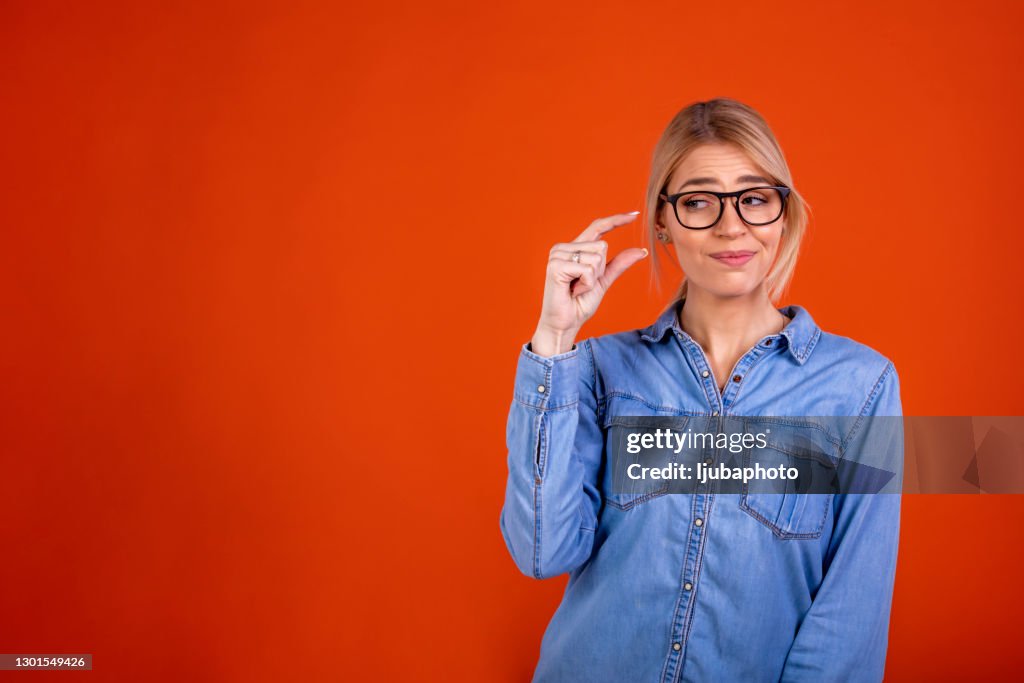 Frustrated millennial woman demonstrating tiny measurement