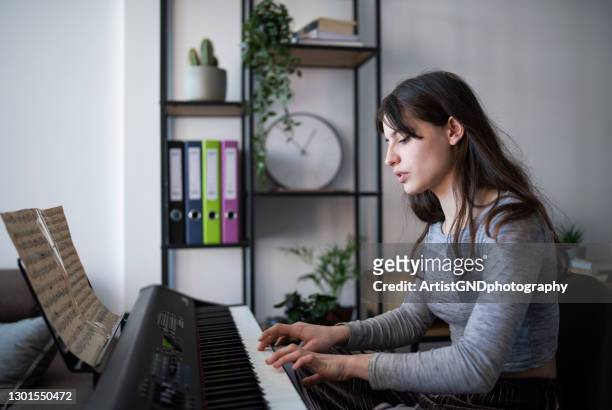 female artist playing piano at home during quarantine. - electric piano stock pictures, royalty-free photos & images