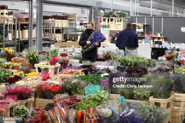 Flowers trades-people work at Covent Garden Market early in the morning on February 11, 2021 in London, England. New Covent Garden market is the...