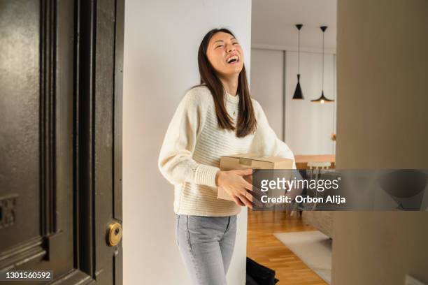 young woman receiving package from delivery man - woman hold box imagens e fotografias de stock
