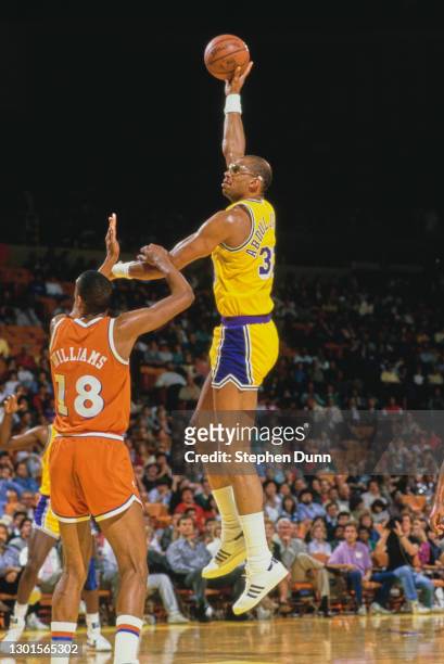 Kareem Abdul-Jabbar, Center for the Los Angeles Lakers jumps to make a single handed lay up shot to the basket over Hot Rod Williams, Center for the...